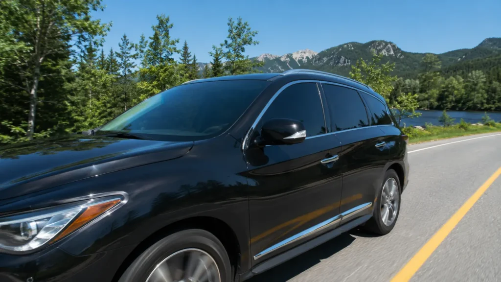 modern car with tinted windows driving on a bright Canadian summer road